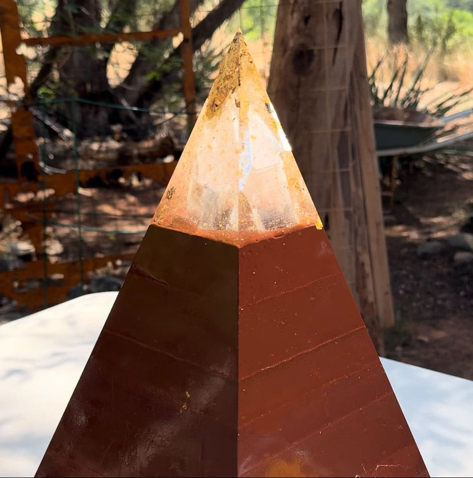 Pyramid-shaped object with a textured surface on a blurred outdoor background